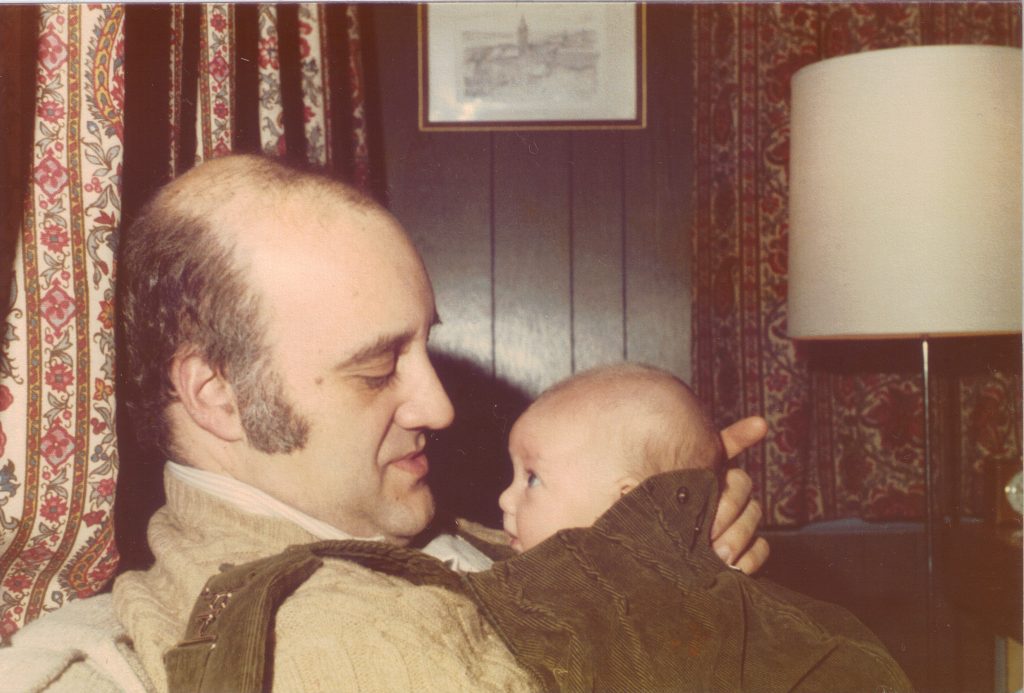 man holding very small baby with a very loving look on his face