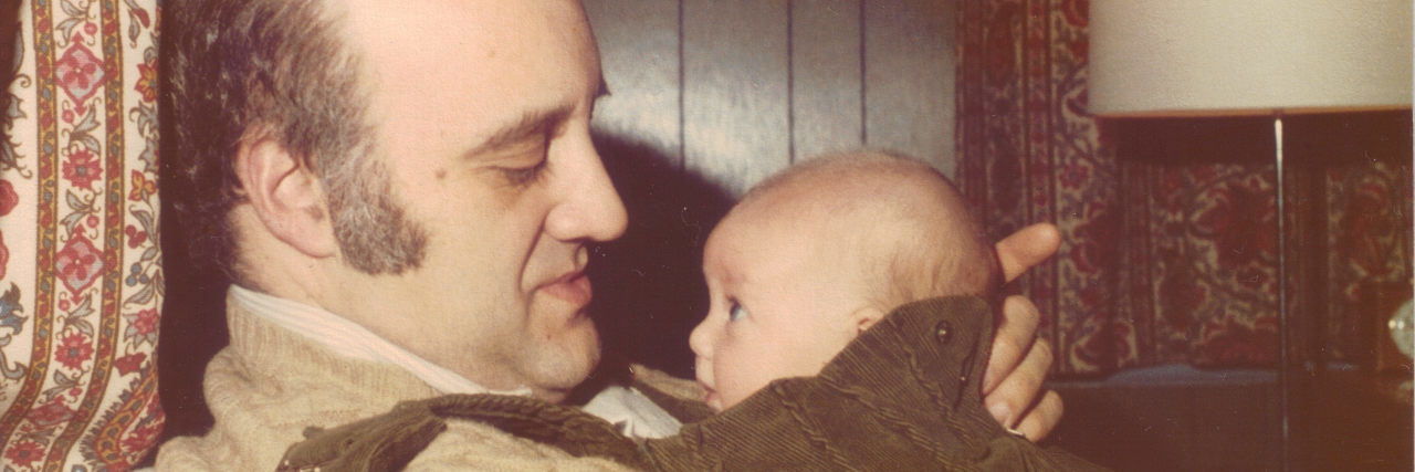 The Grief of Not Being Able to Have Kids Due to Chronic Illness man holding very small baby with a very loving look on his face