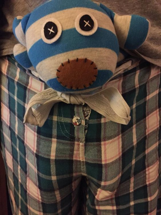 stuffed animal in front waistband of plaid pajama pants