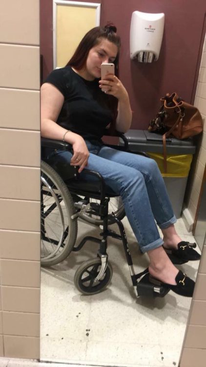 woman in wheelchair taking photo of herself in a full length mirror