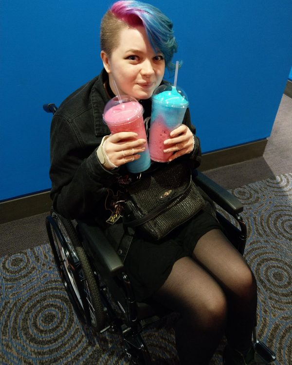 woman in wheelchair holding two slurpee drinks