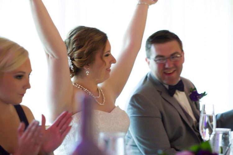 woman in wedding dress raising arms 