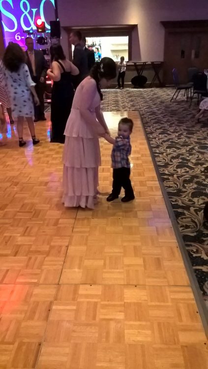 woman dancing with young boy at wedding