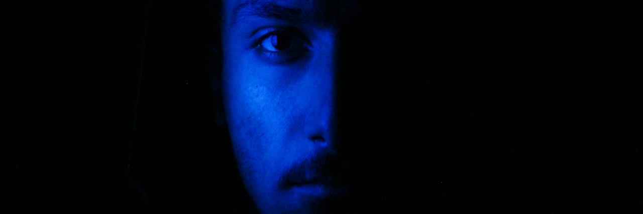 What People Do When They're Having a Hidden Panic Attack half of mans face with black background and he is blue