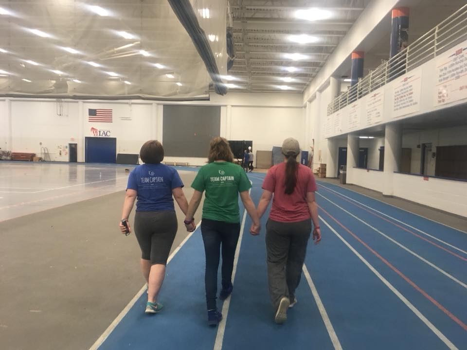 three women walking on an indoor track for relay for life