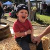 Toddler sitting on hay bale, laughing