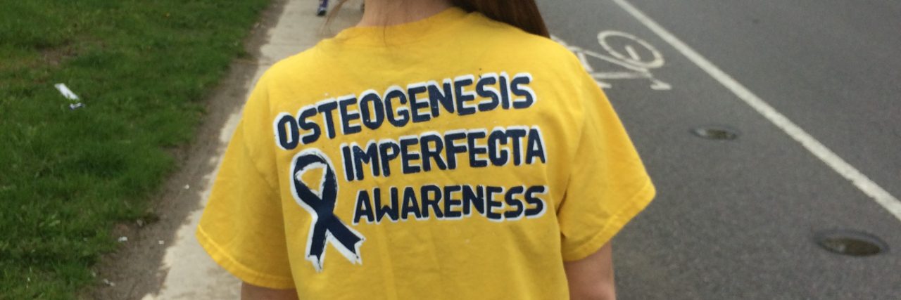The author wearing a shirt that says "Osteogensis imperfecta awareness"