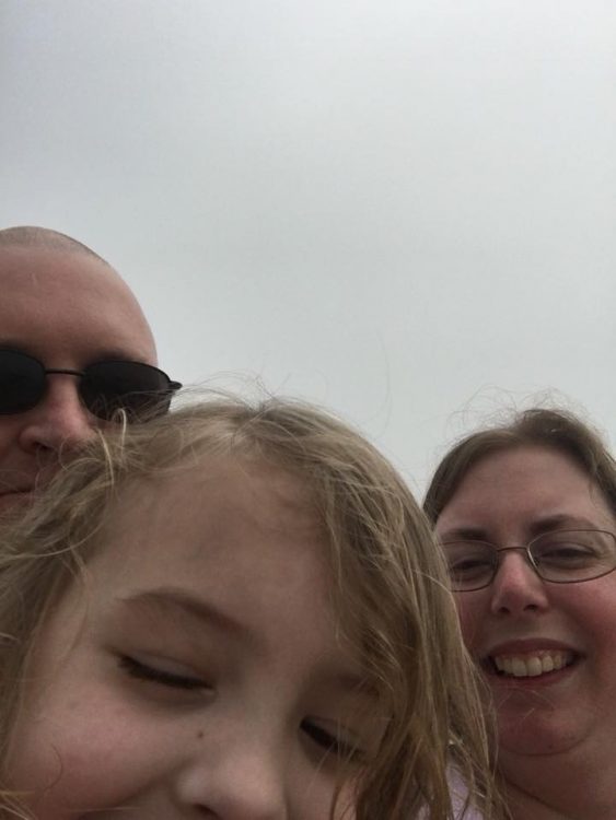 Amanda, her husband, and her daughter smiling