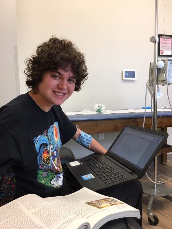 Cheryl's son working on a laptop in the hospital