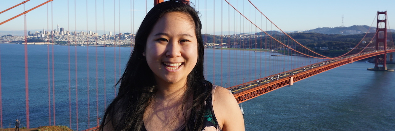 Why We Need to Prioritize Diverse Voices in Eating Disorder Recovery Photo of an asian woman standing in front of the golden gate bridge