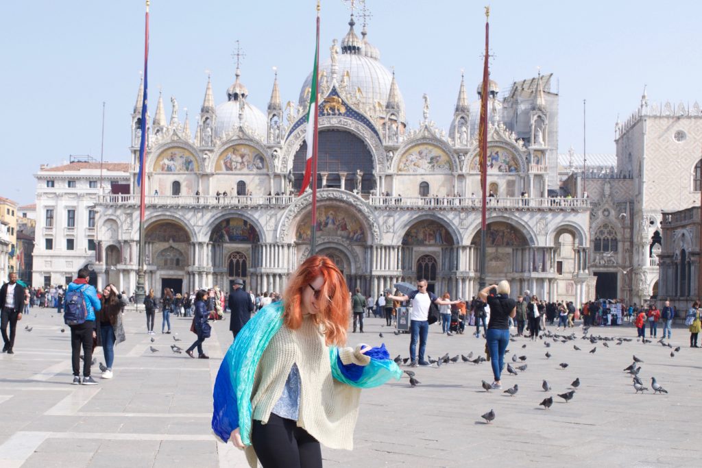 woman with red hair standing in front of a historic building