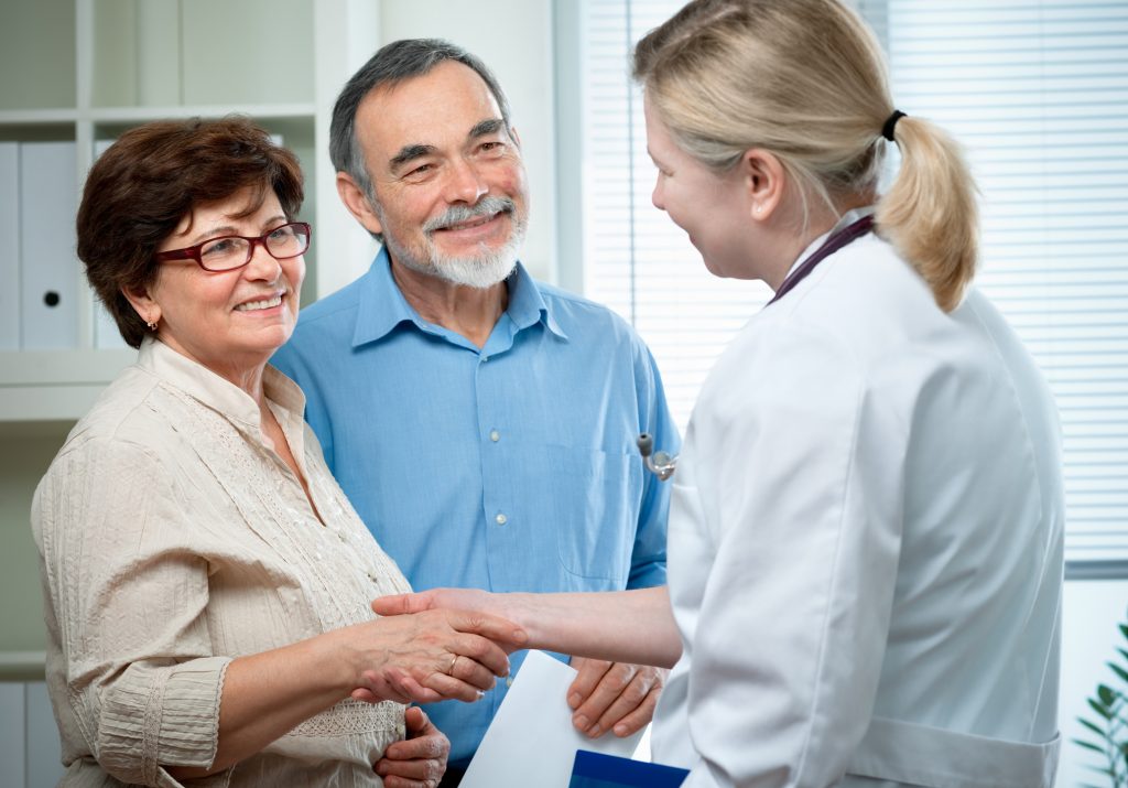 husband and wife greeting a doctor