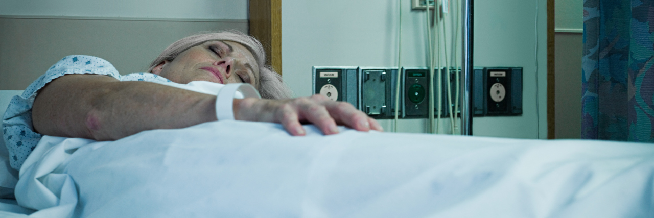 Mature woman lying in hospital bed asleep