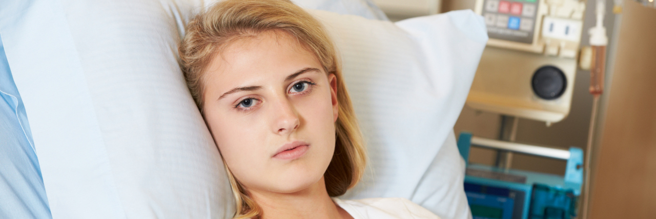 A picture of a teenage girl in a hospital bed, her face radiating sadness.