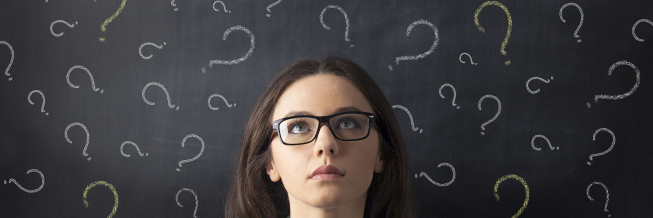 If You Are Asking 'How Do You Do It?' When It Comes to My Lyme Disease A woman looking up at a chalk board with question marks above her head.