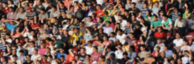 A blurred crowd of people in a stadium.