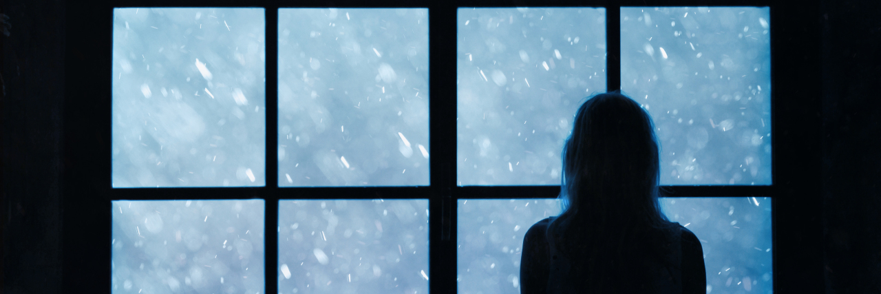 Parenting a Child With Batten Disease and Experiencing Isolation Lonely woman standing and looking out a window