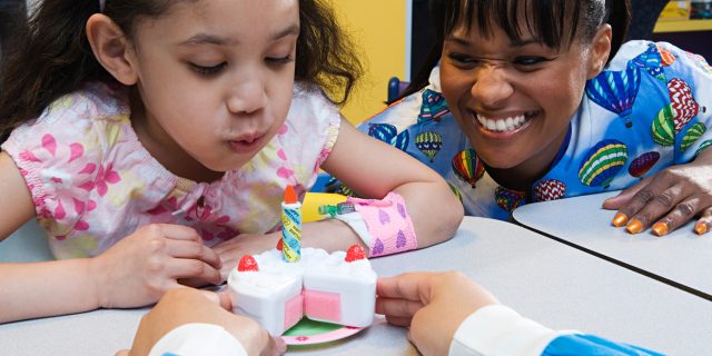 How Volunteering at a Children's Hospital Changed My Perspective of Chronic Illness A woman playing with a child with an IV port in her arm.
