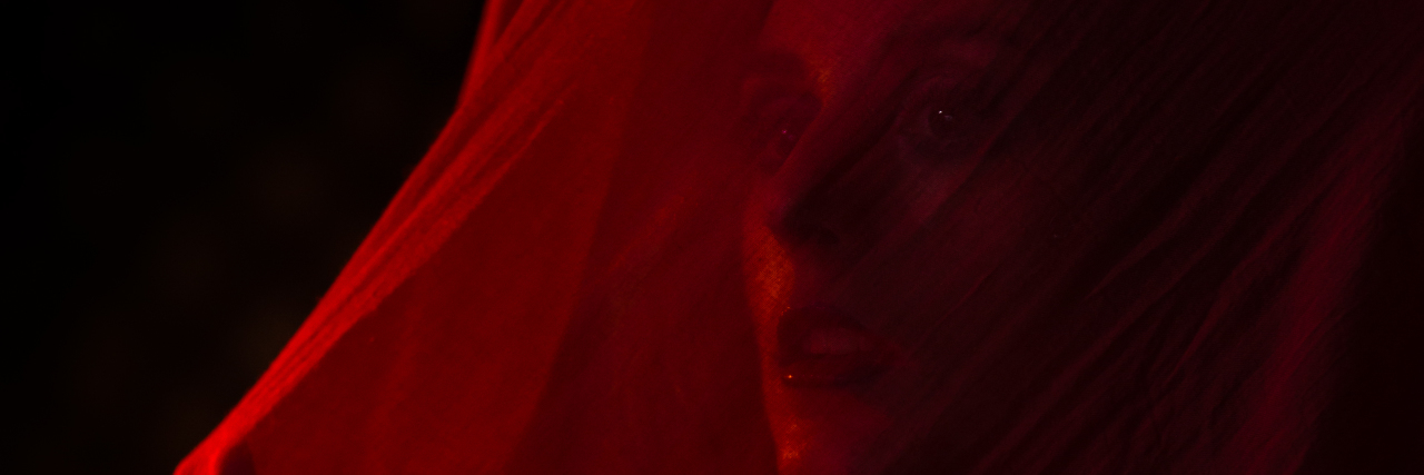 Feeling Invisible as a Woman With ADHD Girl veiled with red fabric.