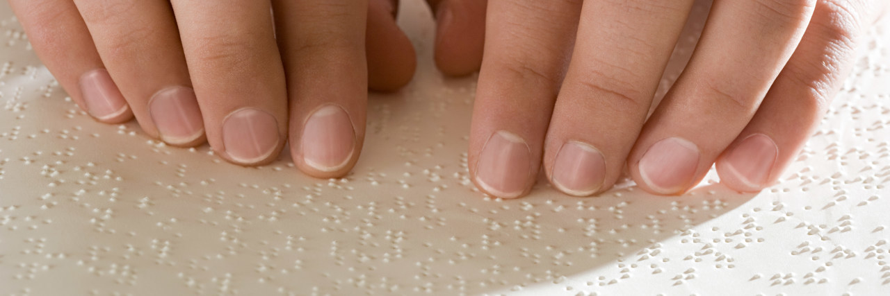 Feeling My Way Through a Sighted World as a Blind Person A woman reading Braille.