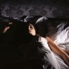 woman lying in bed awake at night