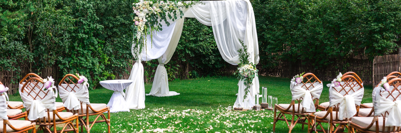 How the 'Marriage Penalty' Affects Me as Someone With a Disability Outdoor wedding ceremony waiting for bride and groom and guests.