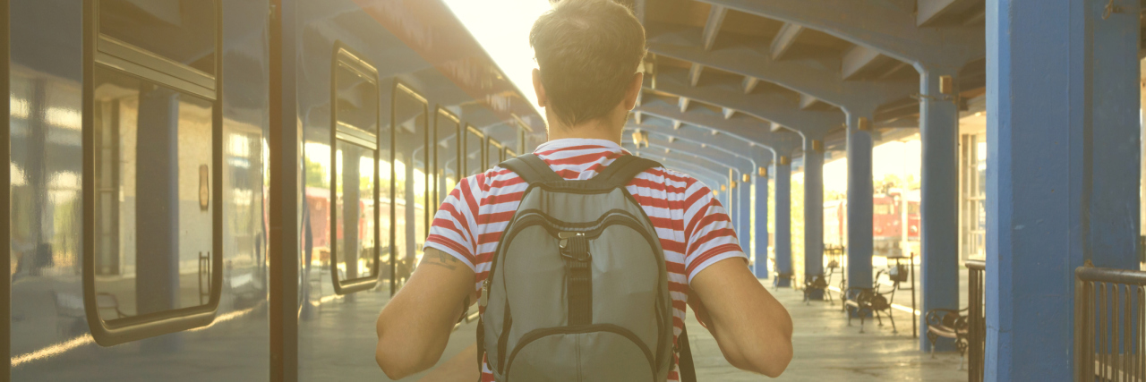 5 Incontinence Products You Need to Know About A man walking on a railway station wearing a backpack.