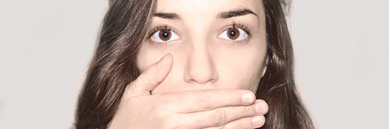 How I Tell My Suicidal Thoughts to Be Quiet Portrait of young girl covering her mouth.