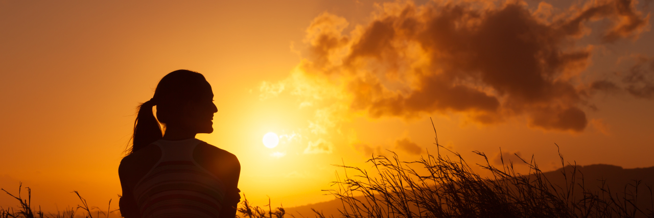 Responding to People Who Call Me Inspirational Woman watches the beautiful sunset/sunrise.