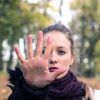 Woman in woods holding hand out in stop gesture