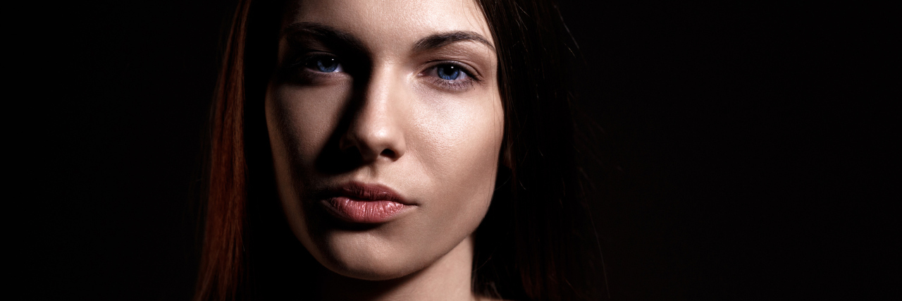 The Reality of Living With Ehlers-Danlos Syndrome portrait of a woman with brown hair wearing a pink, off the shoulder shirt. she has a serious expression