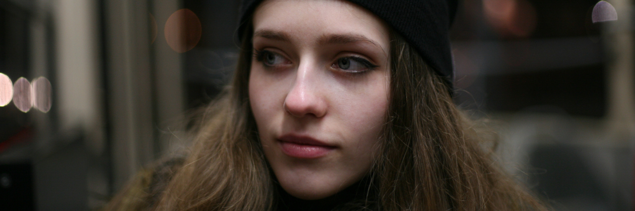 How Fibromyalgia Affects My Mental Health woman wearing a beanie sitting on a bus with tears in her eyes