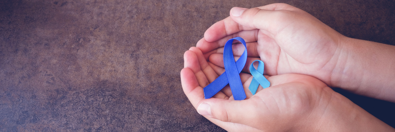 hands holding blue awareness ribbon