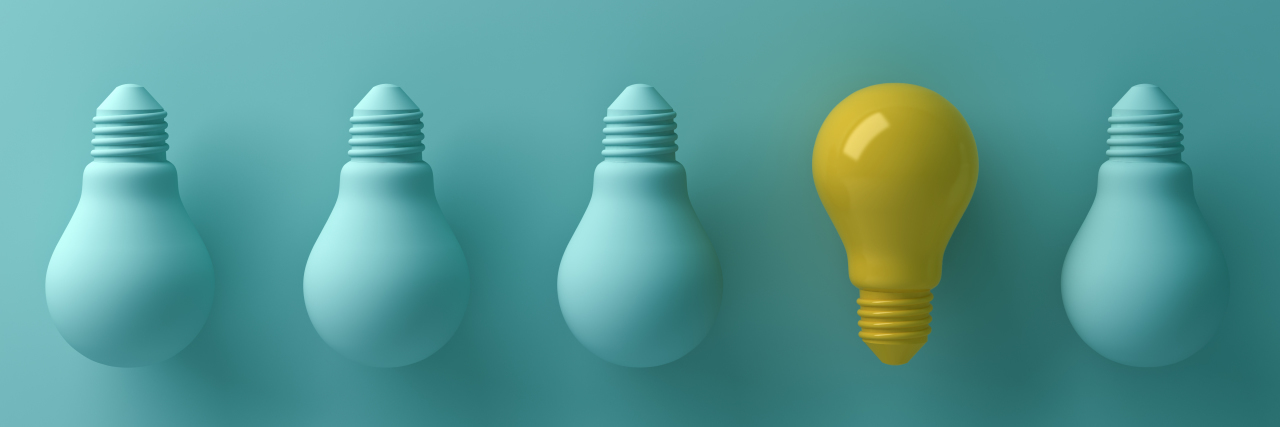 Autism: Different, Not Less One yellow light bulb standing out from the unlit green incandescent lightbulbs.