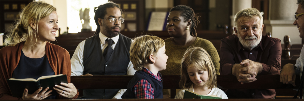 Autism in the Church People at church, mother with two chilren, the boy is distracted and looking around.