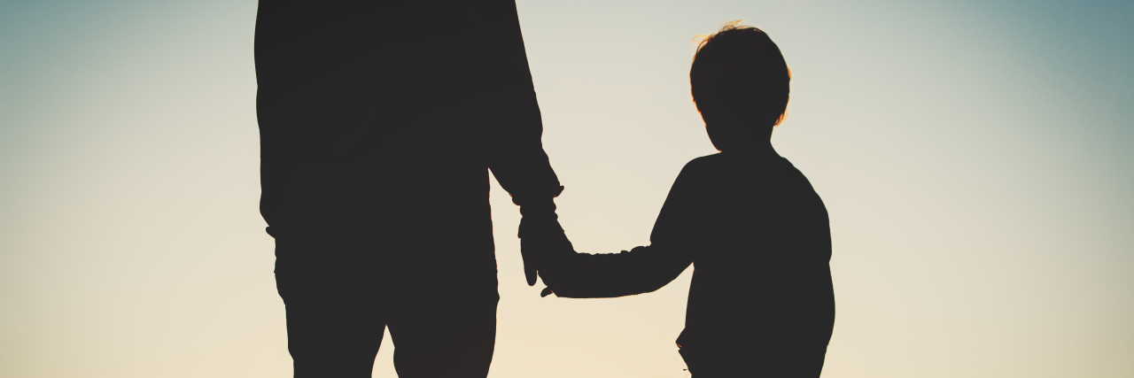 What You Learn When Parenting a Child With Duchenne Muscular Dystrophy silhouette of father and son holding hands at sunset sky