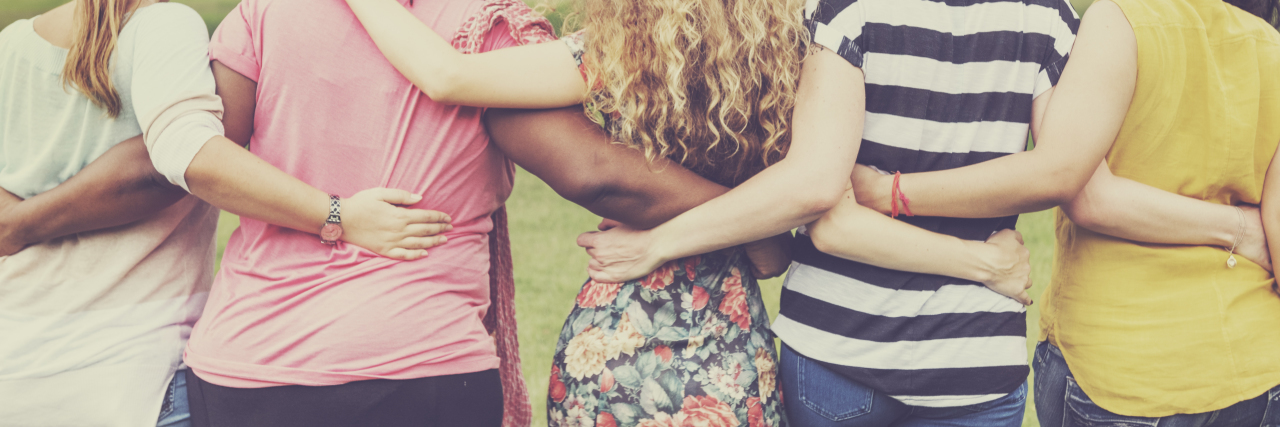 Having a Support System With Chronic Pain women arm in arm, with their backs showing