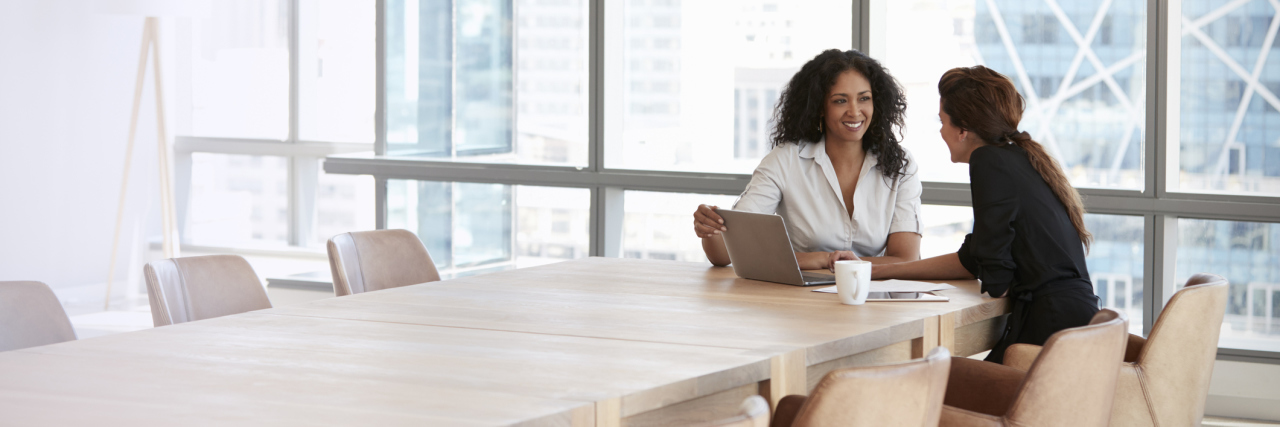 Communicating With Your Workplace About Your Illness two businesswomen talking in a conference room