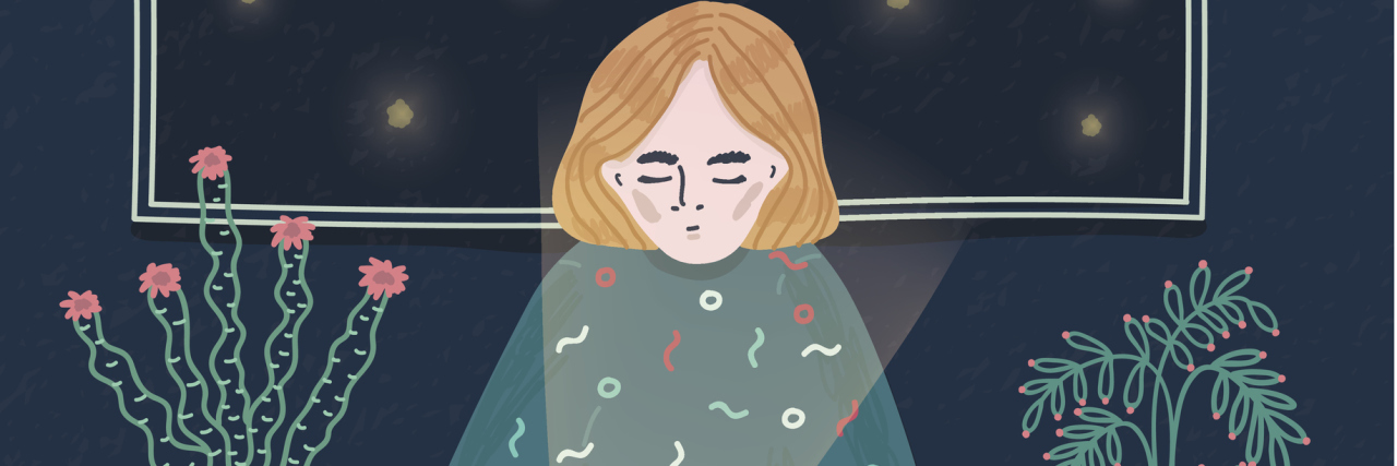 5 Thoughts That Often Go Through My Mind as I Live With Fibromyalgia A graphic of a woman sitting alone at night, at a desk, looking at her phone.