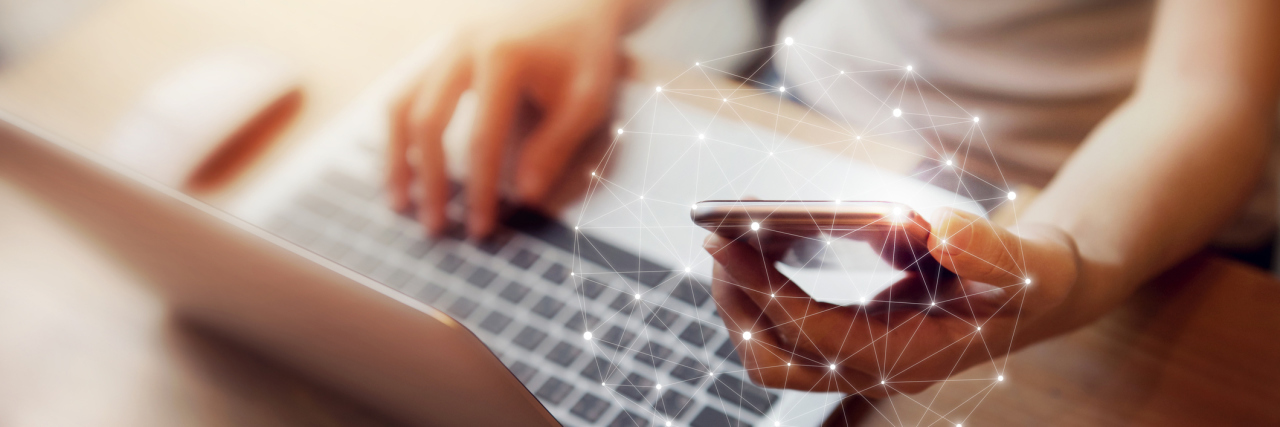 What to Know If You're Involved in an Online Support Group woman sitting at a desk using her computer and cell phone