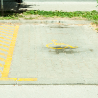 Reserved parking lot space for people with disabilities with a disability sign on the ground.