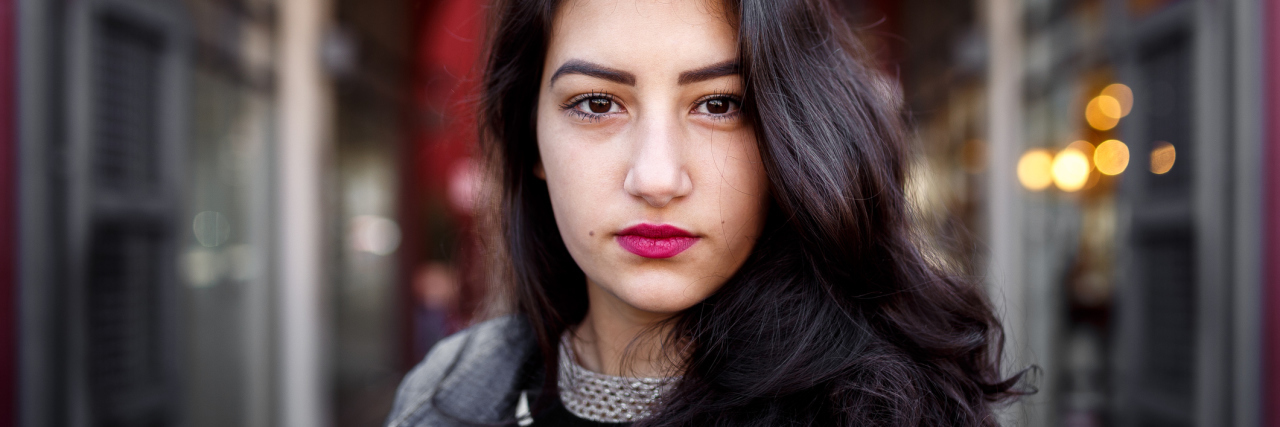 When Your Family Gives You Advice on Your Body and Your Pain portrait of a woman standing outside looking serious