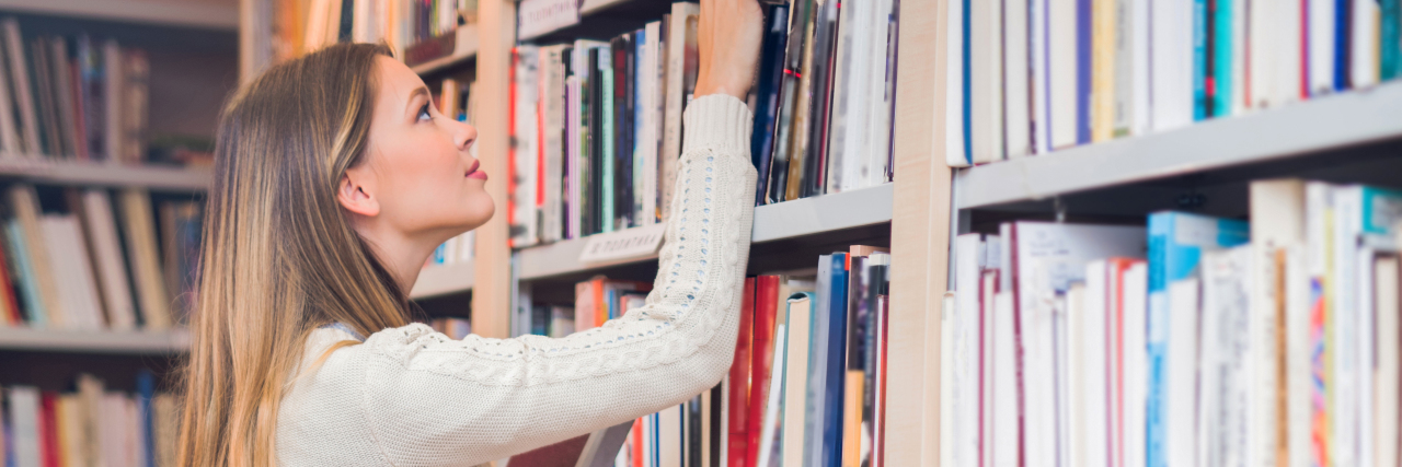 Advice for Parenting Kids With Rare Conditions Woman standing on ladder searching for books in a library