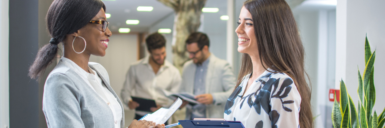 How to Tell Your Boss and Colleagues About Your Illness two businesswomen talking in their office