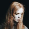 blurred photo of a woman with long red hair looking down and away