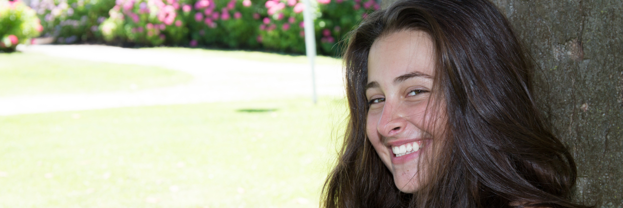 What Smiling Means to Me as a Person Who Stutters Smiling beautiful young woman outdoors in sun day park