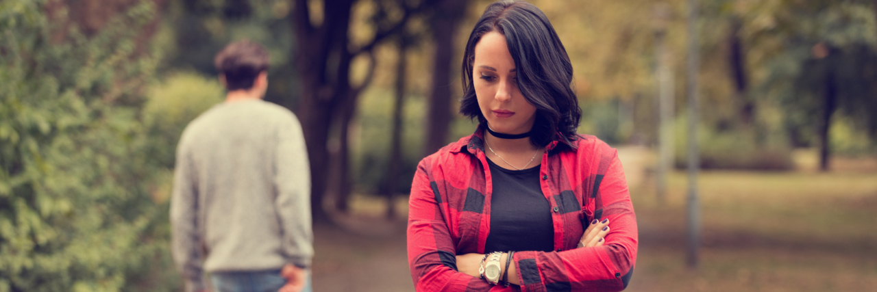 If You Want to End a Friendship With Someone Who Is Chronically Ill A woman standing with her arms crossed as a guy walks away from her.
