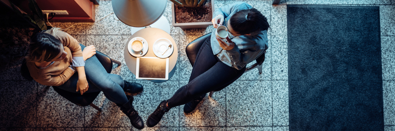 two women talking over coffee in a cafe