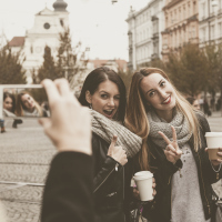woman taking a photo of two friends posing and smiling