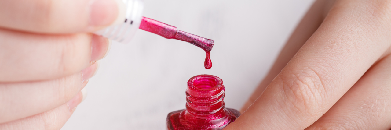 My Biggest Accomplishment Today Was Painting My Toenails A woman opening a red nail polish bottle.
